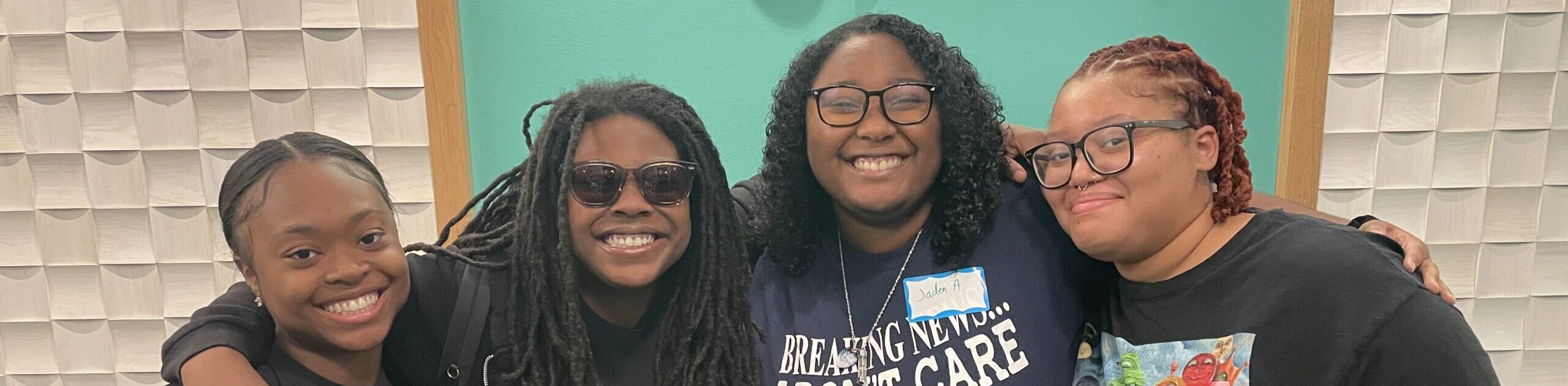 Four Black young women pose smiling